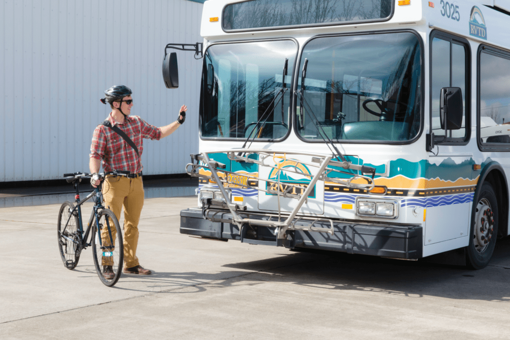 Transportation by bus and bicycle. Man waving.