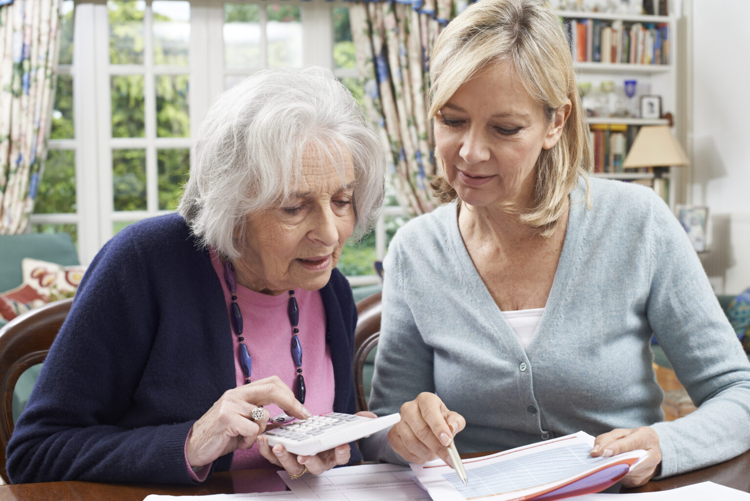 Elderly mother and daughter working together for estate planning.