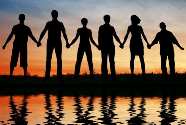 Standing hand in hand with a golden sky as the sun sets.
