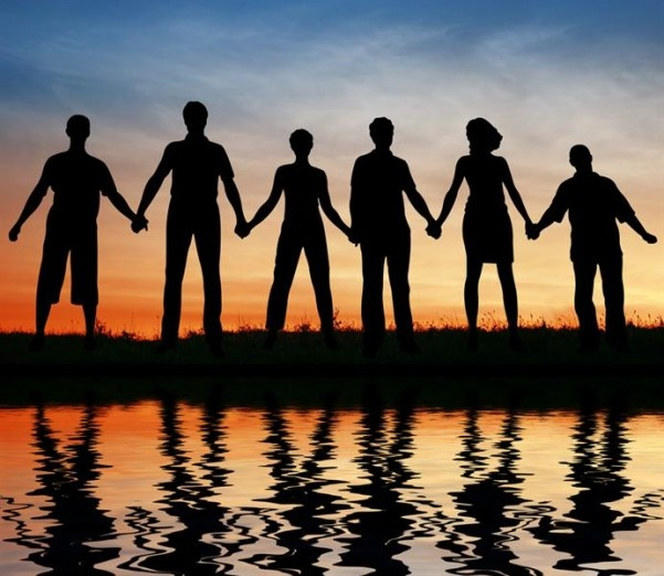 Standing hand in hand with a golden sky as the sun sets.