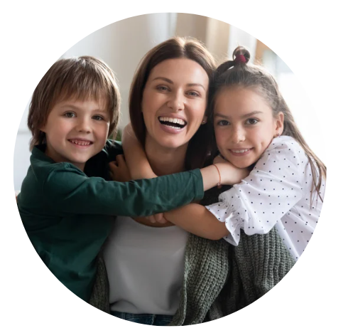 Mom smiling with two children on each side of her hugging.